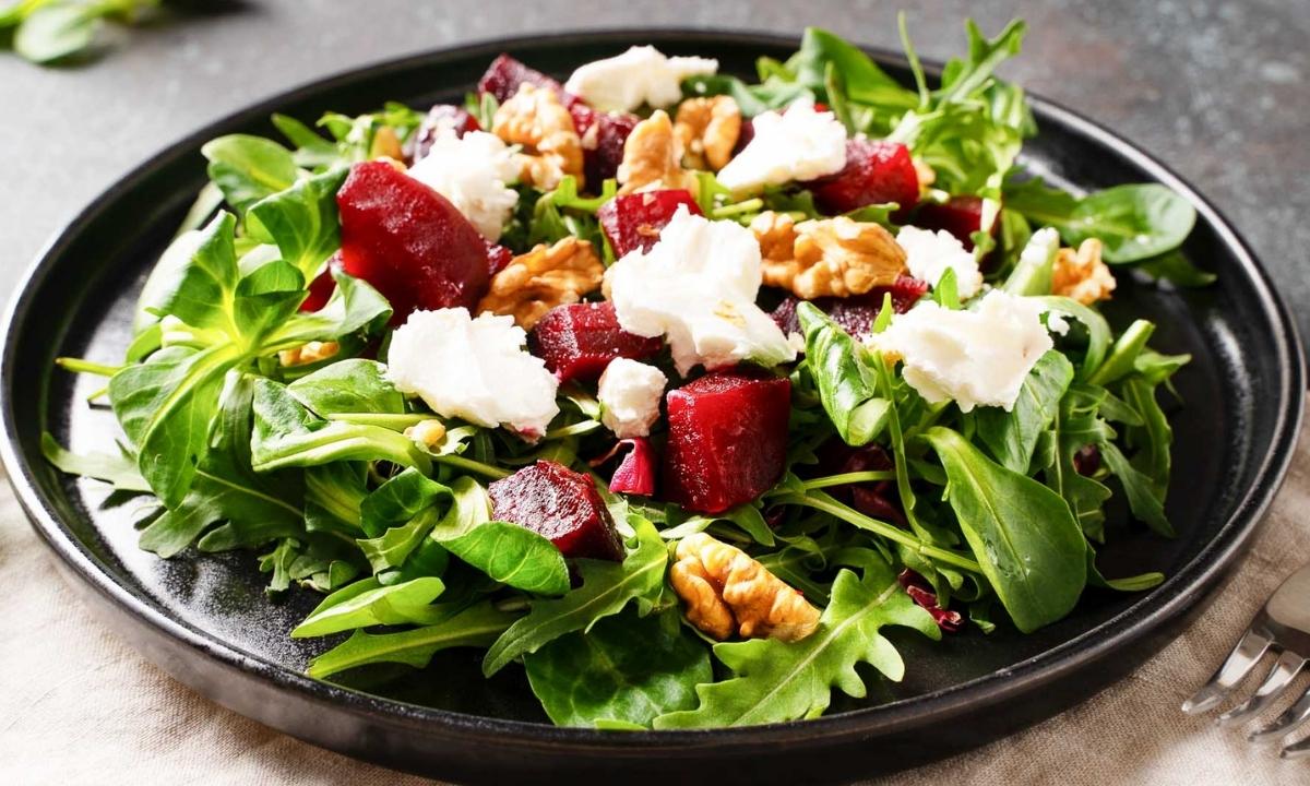 top view of a roasted beet salad with greens, walnuts and cheese