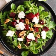 top view of a roasted beet salad with greens, walnuts and cheese
