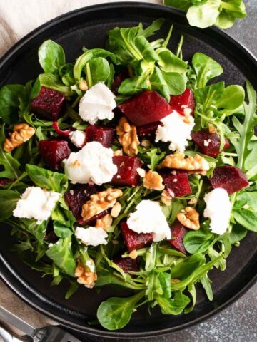 top view of a roasted beet salad with greens, walnuts and cheese