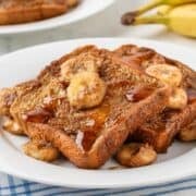 banana french toast in a white dish with banana slices on top