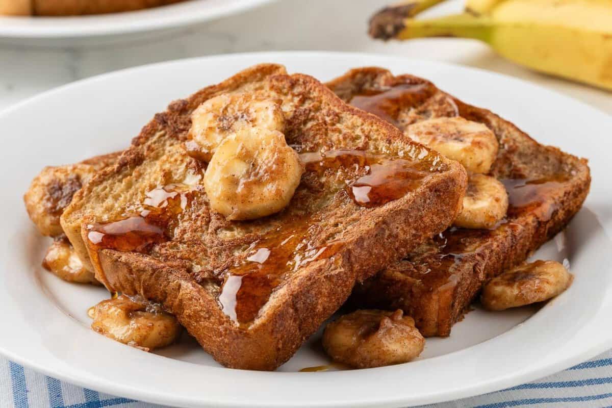 banana french toast in a white dish with banana slices on top