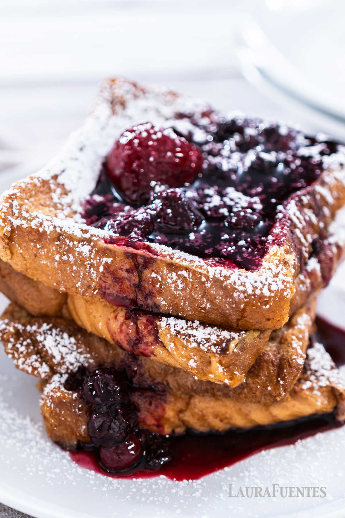 large stack of french toast topped with blueberry sauce