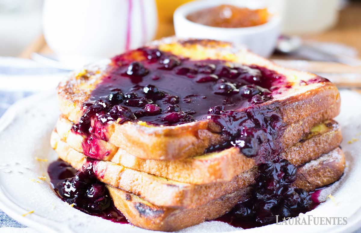 stack of four slices of French toast topped with blueberry sauce