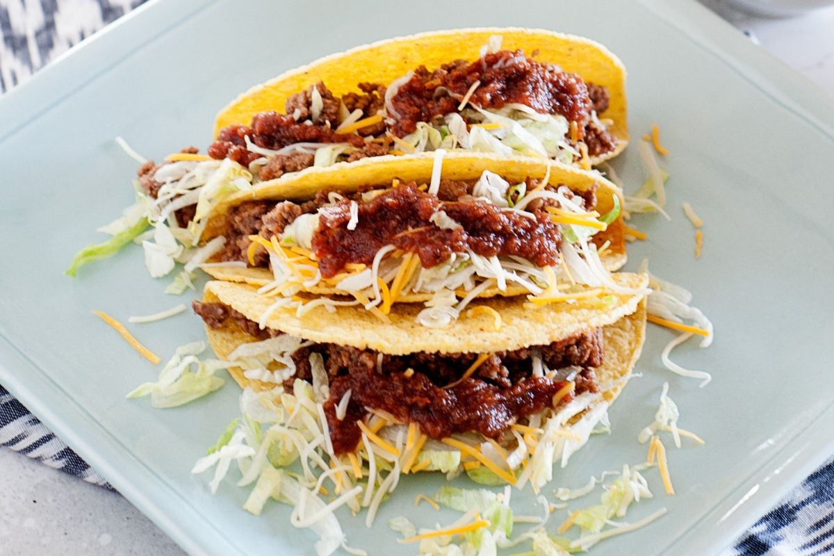 crunchy beef tacos with cheese and lettuce toppings