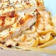 grilled blackened chicken sliced on top of alfredo pasta