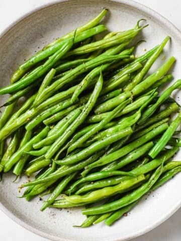 overhead view of steamed green beans in a white dish