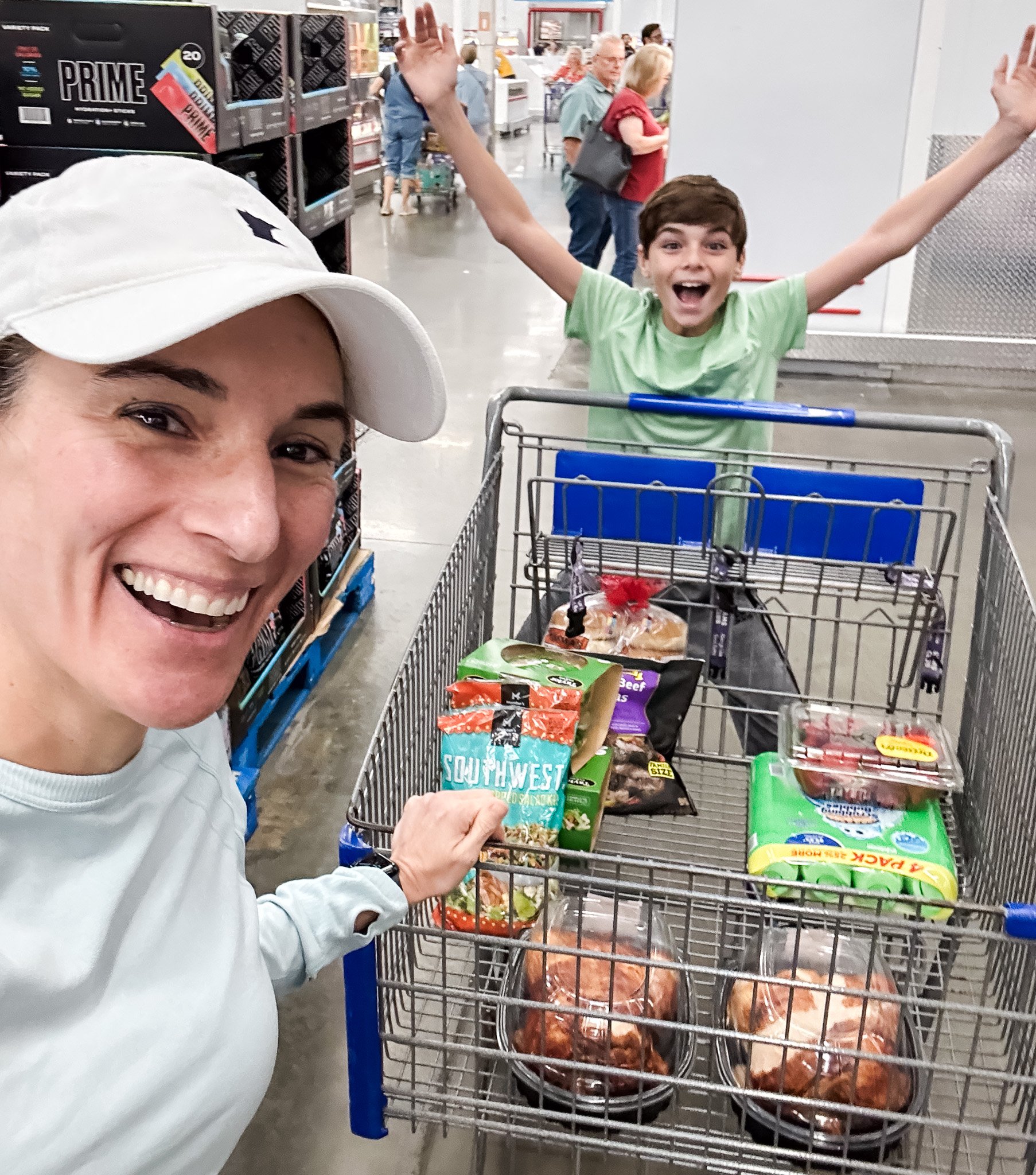 Laura and son with a cart full of groceries