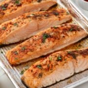 overhead close up view of baked frozen salmon on a baking sheet.