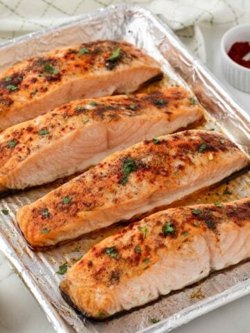 overhead view of baked frozen salmon on a baking sheet.