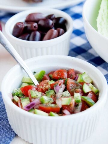 a bowl with cucumber salsa and smaller bowl behind with olives