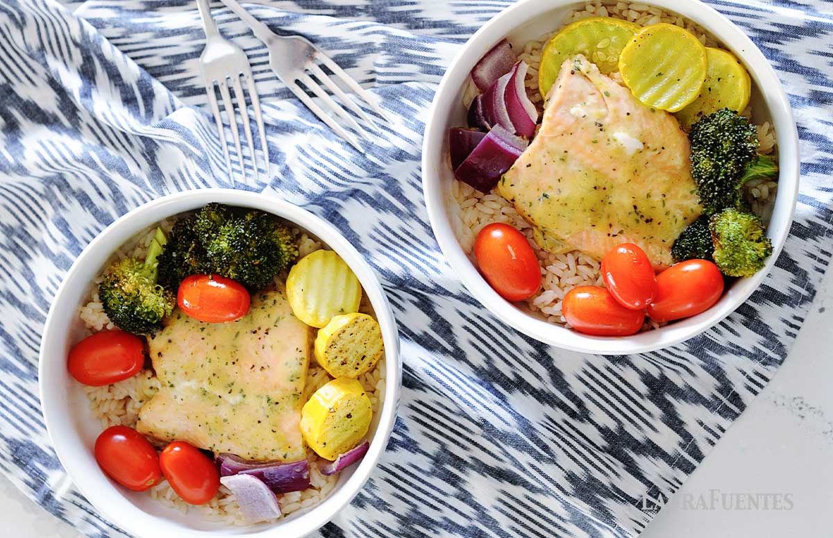 two bowls of baked salmon, vegetables and rice
