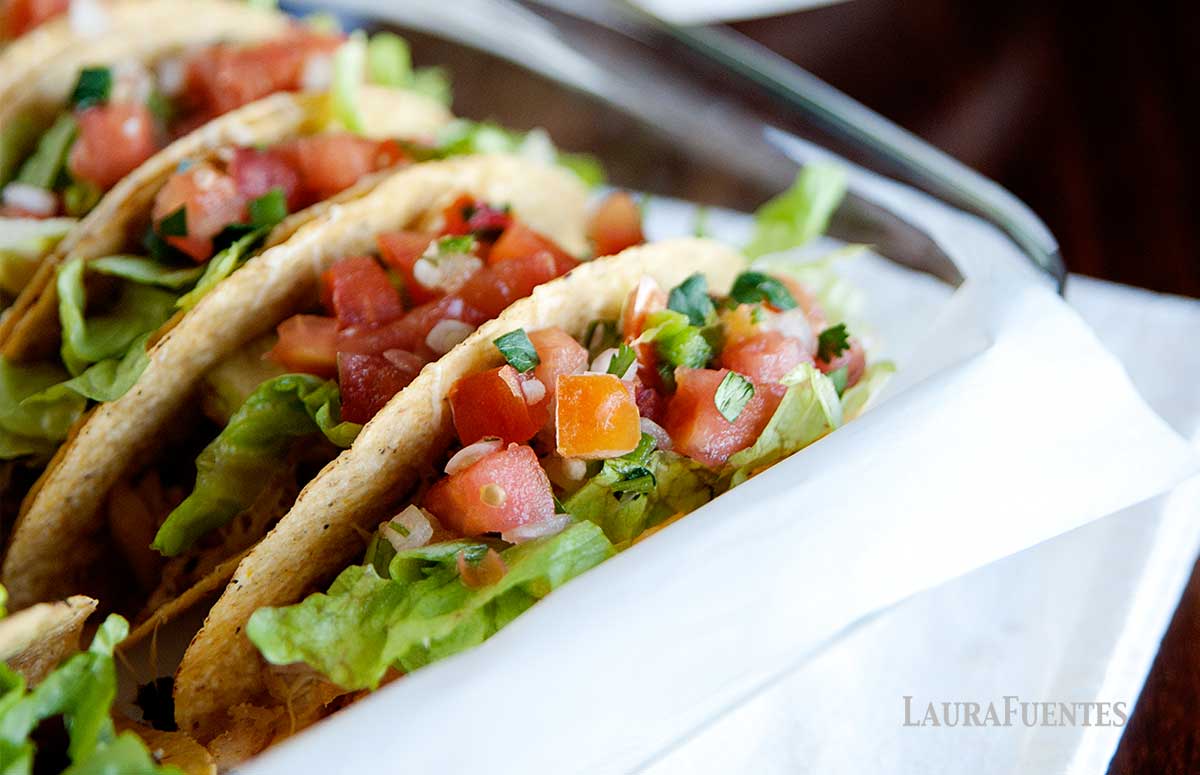 a baking dish with rotisserie chicken tacos