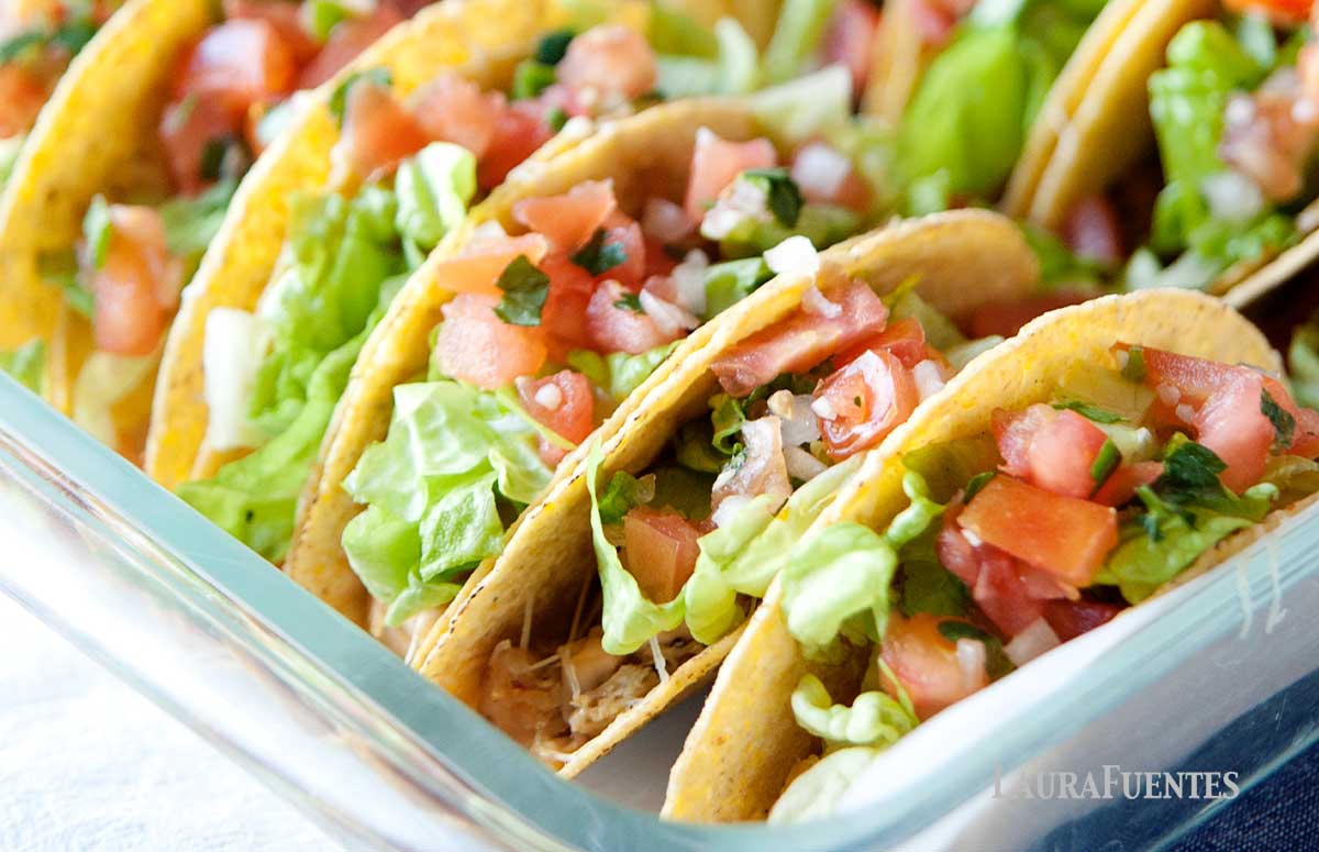 a baking dish with rotisserie chicken tacos