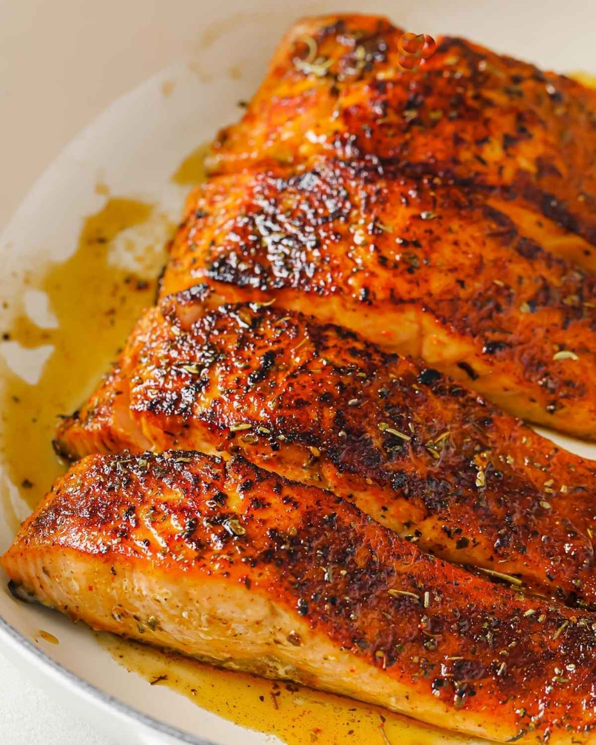 four salmon fillets in a pan