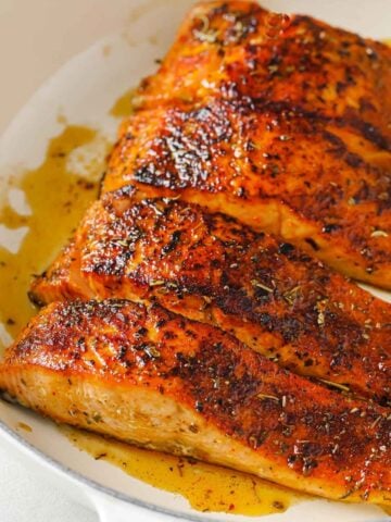 four salmon fillets in a pan