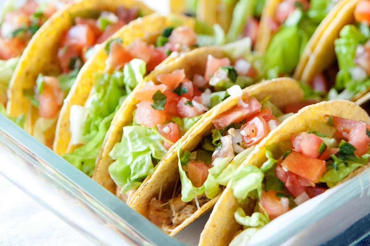 a baking dish with rotisserie chicken tacos