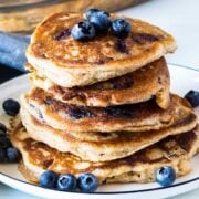 stack of blueberry pancakes topped with additional blueberries