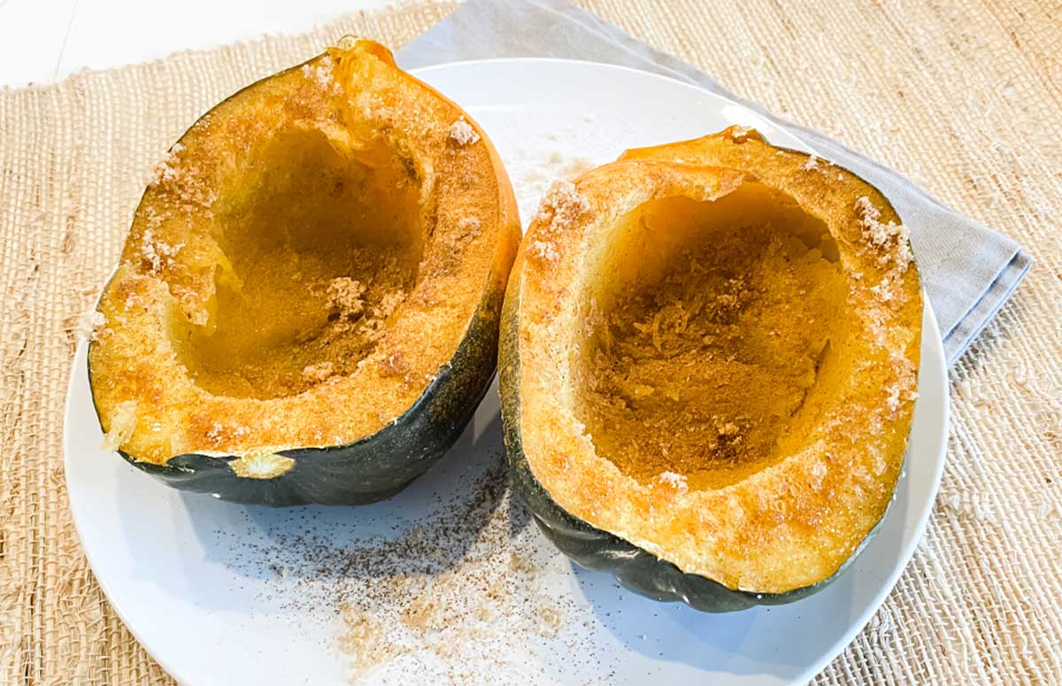 two acorn squash halves on a plate from the microwave