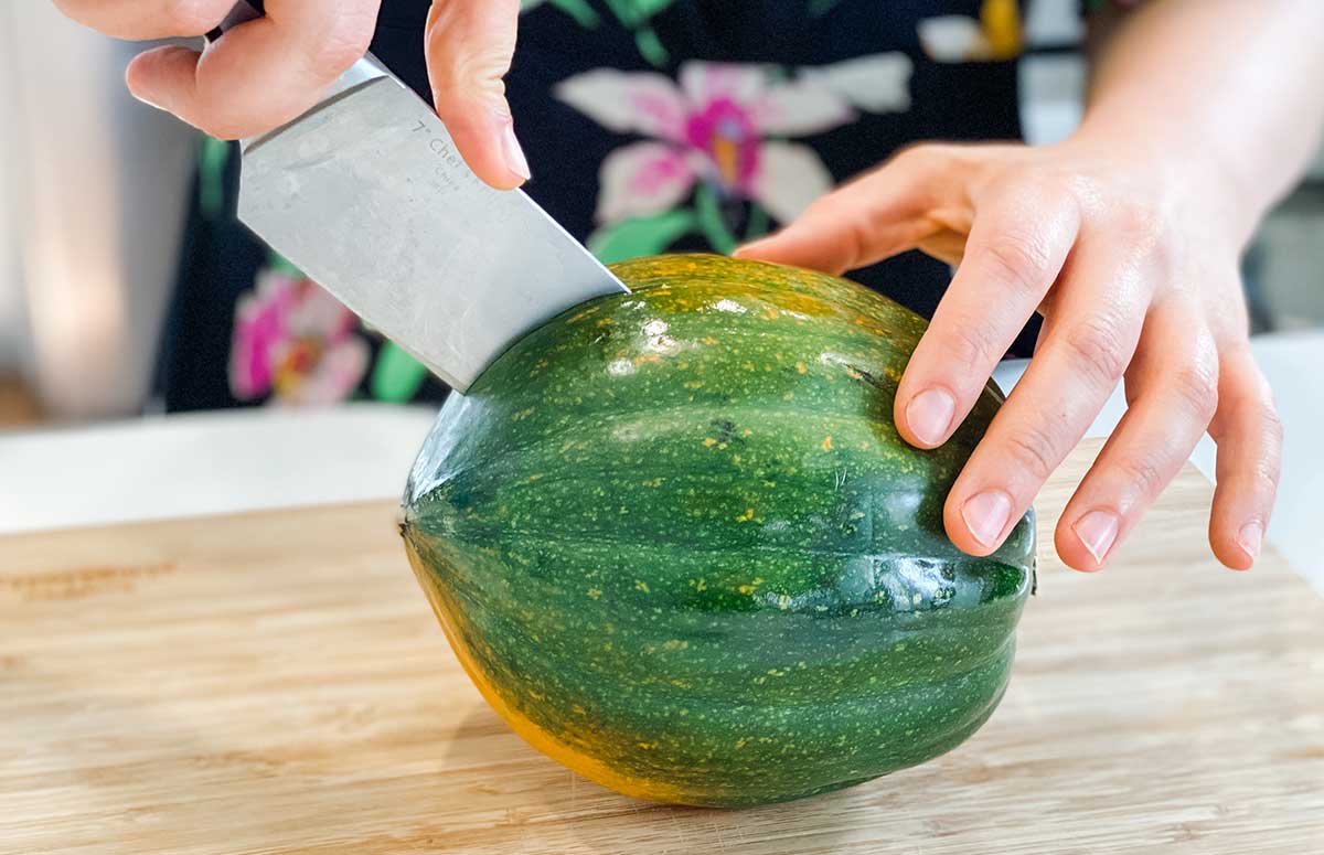 slicing through a whole acorn squash