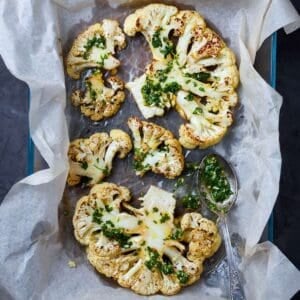 roasted cauliflower steaks in a lined baking dish
