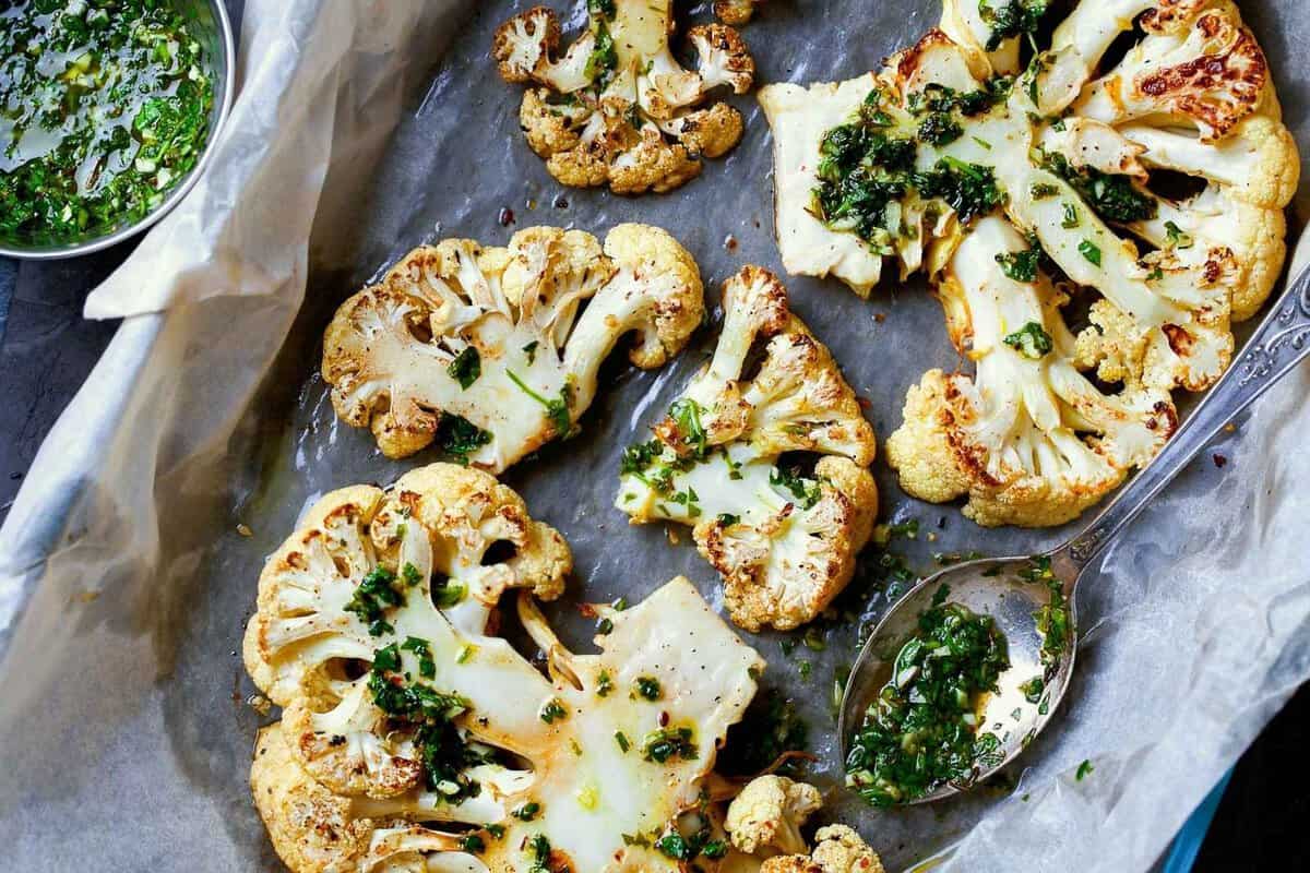 roasted cauliflower steaks in a lined baking dish