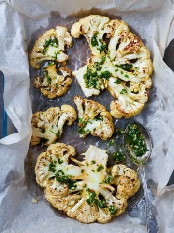 roasted cauliflower steaks in a lined baking dish