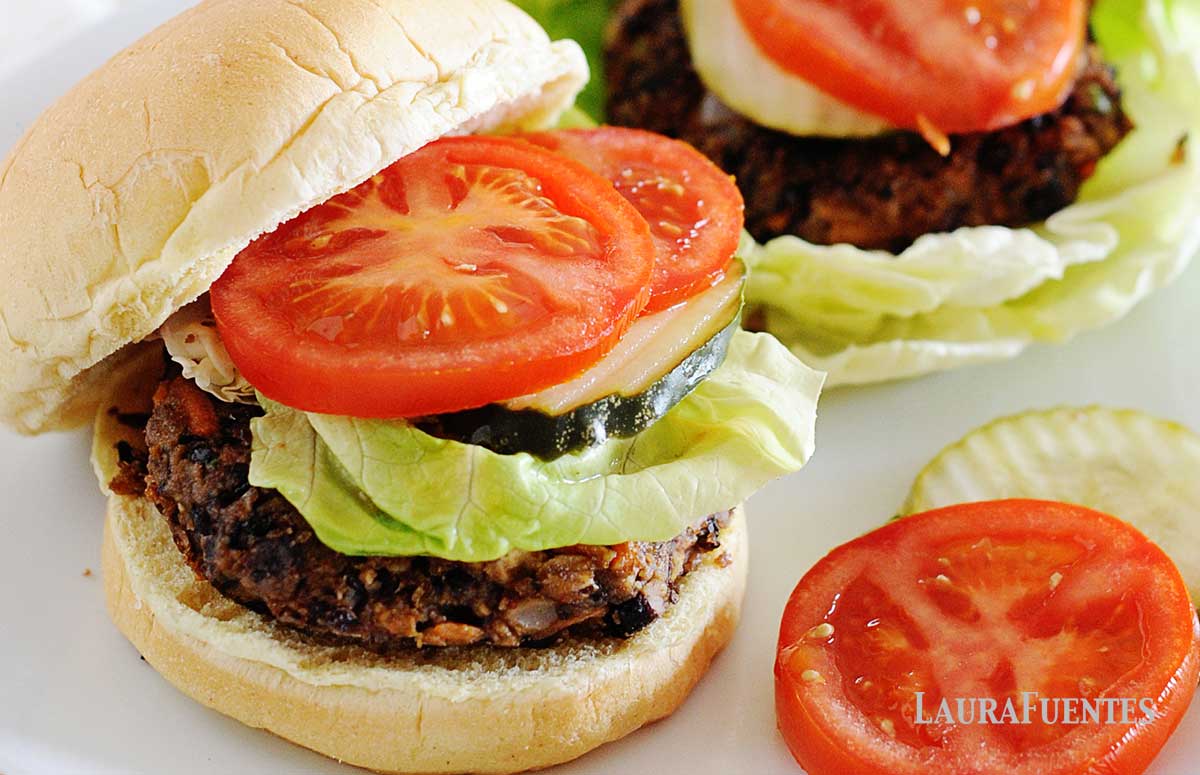black bean burgers on a plate with tomatoes and lettuce