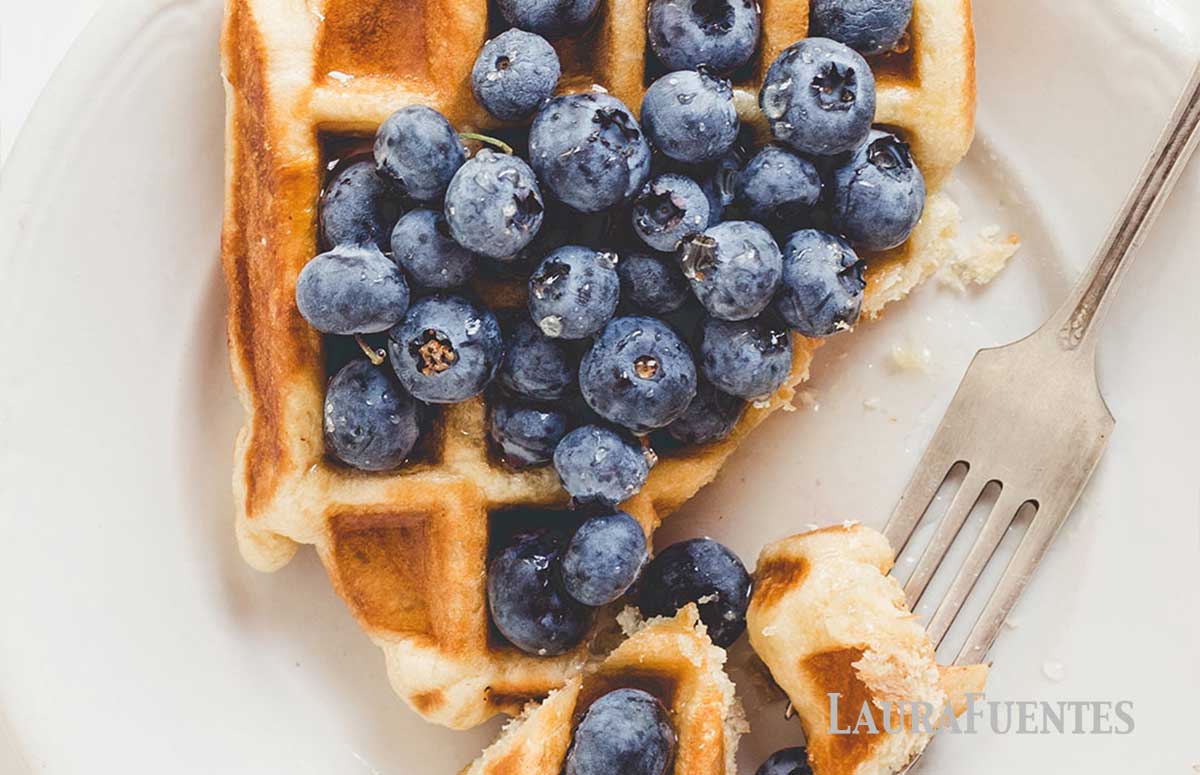 closeup of a waffle topped with lots of blueberries