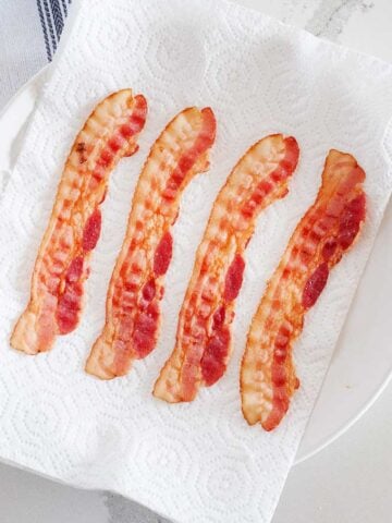 four strips of chicken on a plate with paper towels