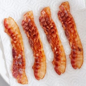 four slices of crispy bacon on paper towels