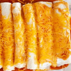 rotisserie chicken enchiladas in a pan with melted cheese on top