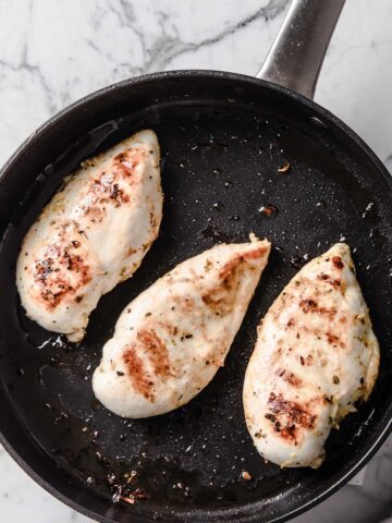 three chicken breasts in a pan