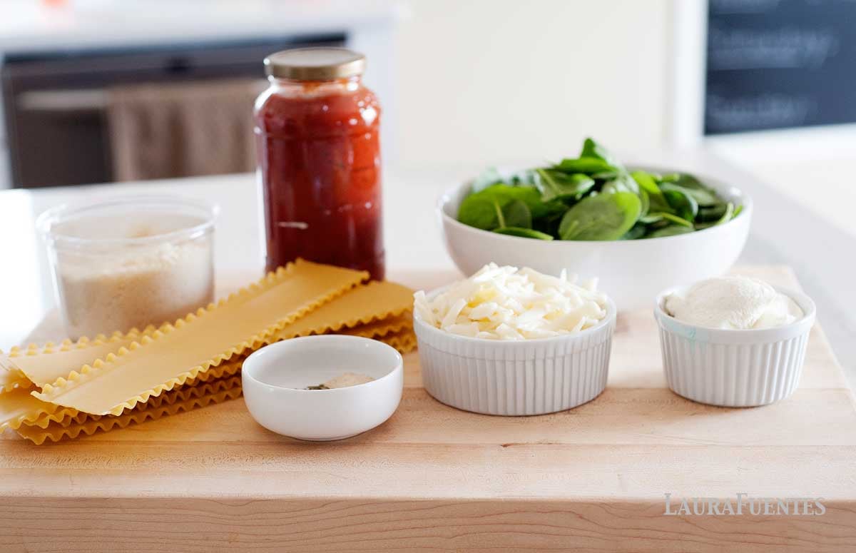 ingredients to make no bake lasagna: nodles, sauce, spinach, cheeses on the counter