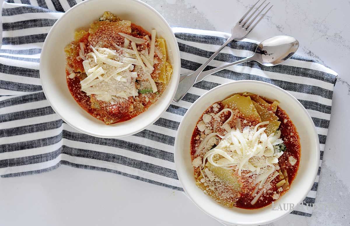 two bowls of easy lasagna topped with shredded cheese