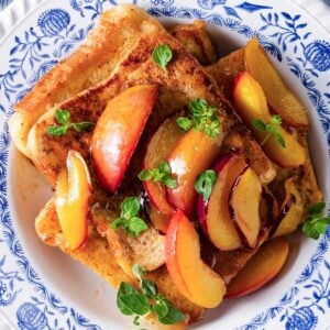 stack of French toast topped with peaches