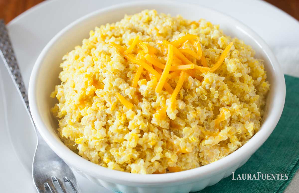 large bowl of cheesy quinoa topped with shredded cheddar cheese