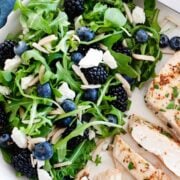 arugula blueberry salad with a chicken breast on a plate