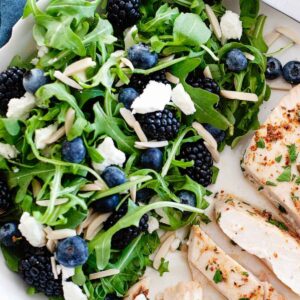 arugula blueberry salad with a chicken breast on a plate