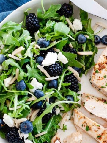 arugula blueberry salad with a chicken breast on a plate
