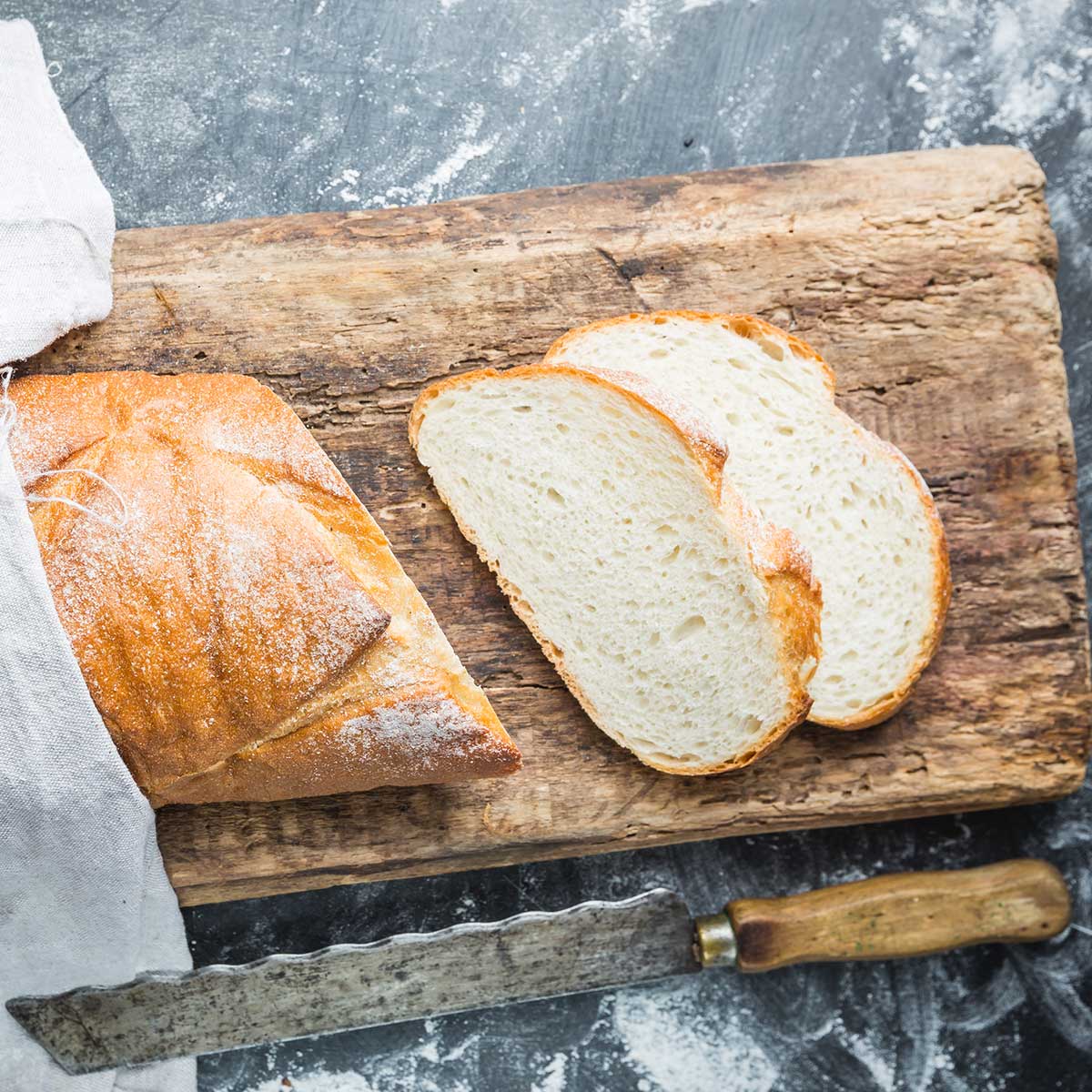French bread on a cuttin board with two slices cut