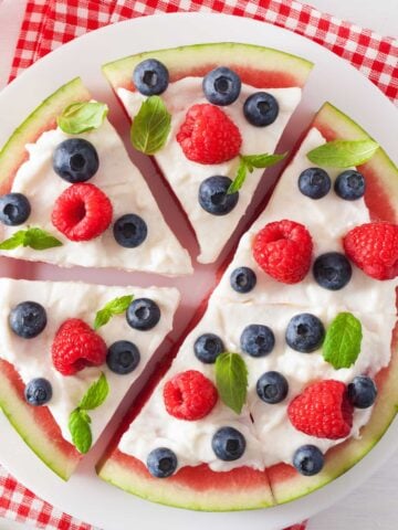 watermelon pizza topped with yogurt and berries