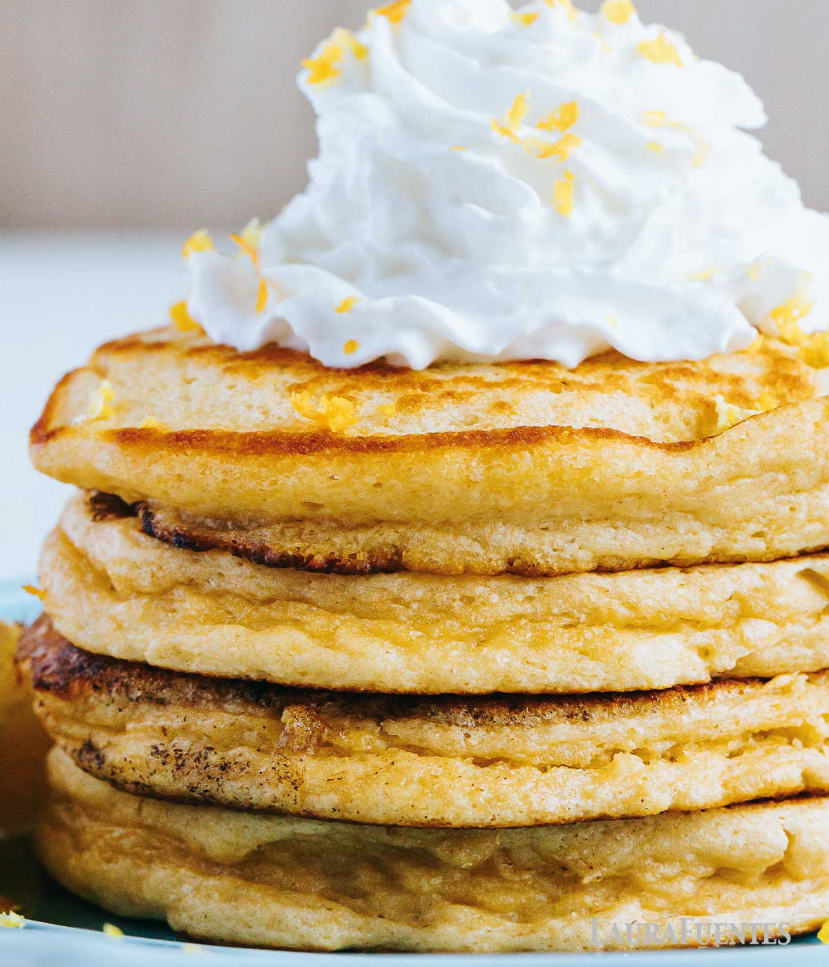 stack of four pancakes topped with whipped cream