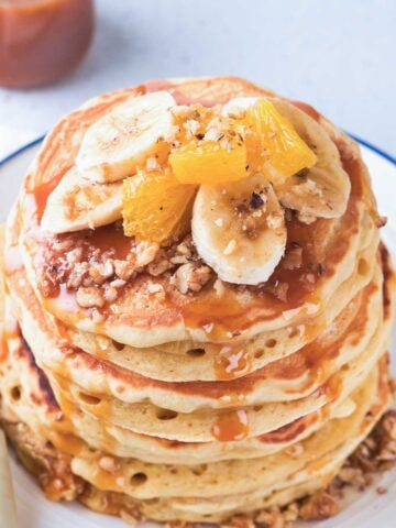 stack of pancakes with fruit and nuts