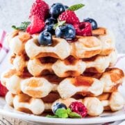stack of waffles topped with raspberries and blueberries