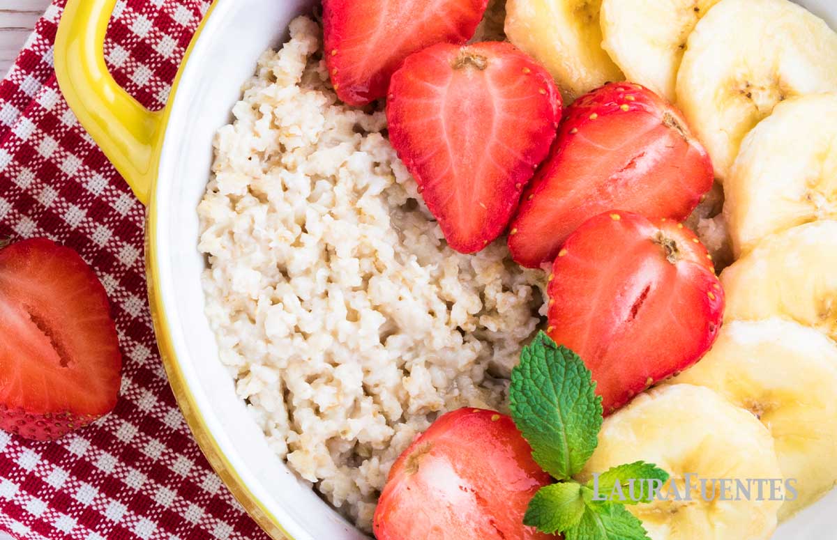 a bowl of oatmeal topped with sliced banana and strawberries