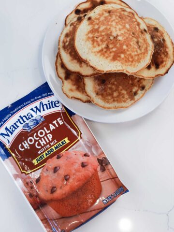 stack of pancakes with a bag of muffin mix