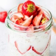 a jar with overnight oats and strawberries on the top