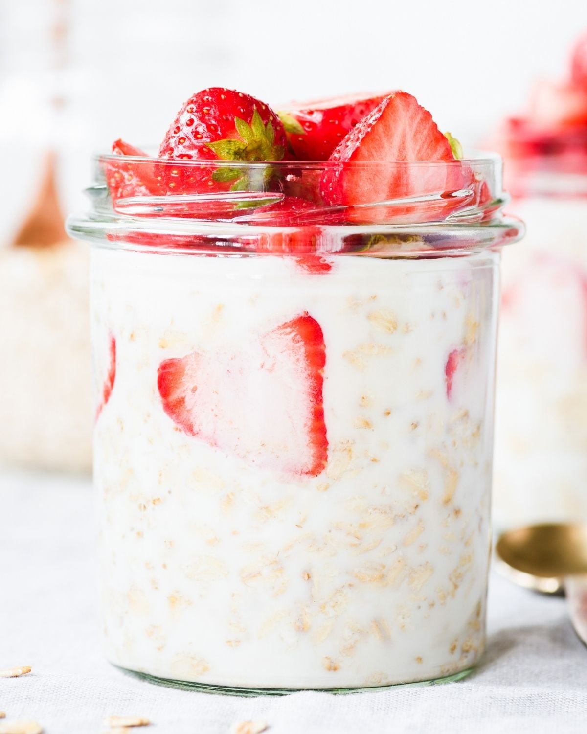 two jars of overnight oats and strawberries on the top