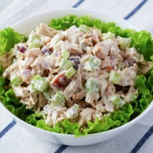 a bowl with a bed of lettuce and chicken salad on top