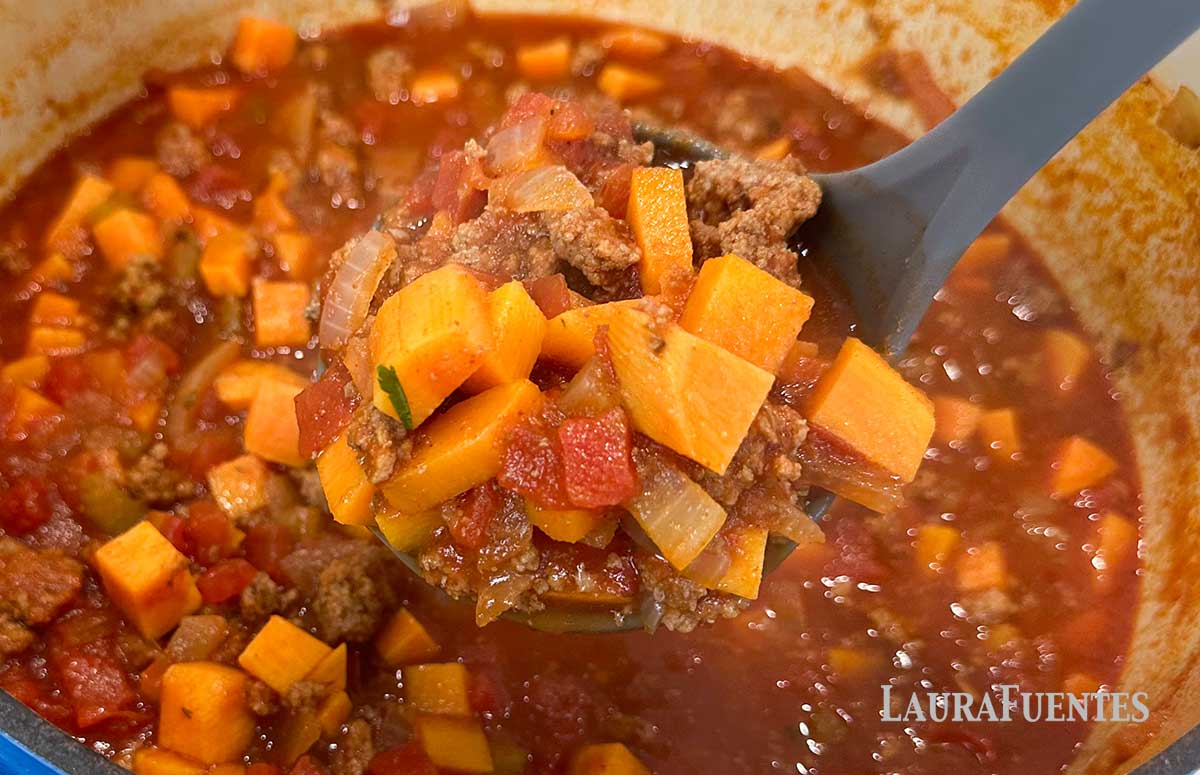 a spoonful of sweet potato chili over a chili bowl